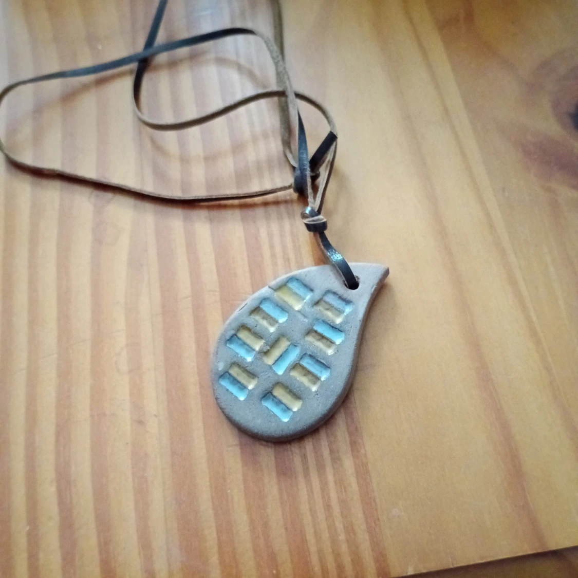 Halsband med hänge o läderband.