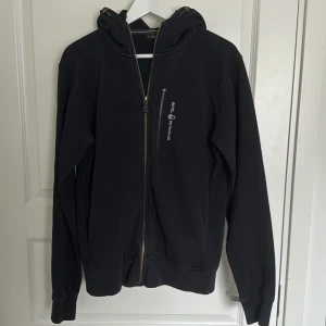 Sail racing fleece (svart) - Svart sail racing fleece, ganska sliten. Trasig vid dragkedjan på fickan men går fortfarande att öppna/stänga. Allmänt bra skick men sliten.