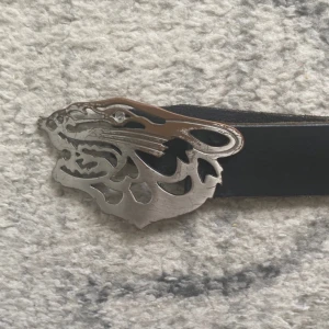 Tiger Of Sweden Bälte - Bältet är i bra skick men tiger är lite rostig som syns på bilden. 110 cm lång med en bredd på 4cm. Skriv ifall du har några fler frågor!