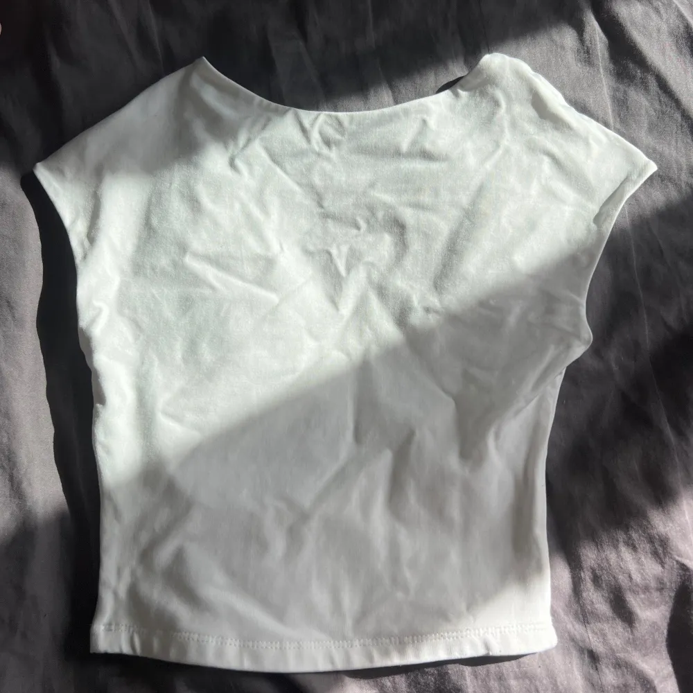 en vit t-shirt med öppen rygg. super fin. tjockt material så man ser inte genom mycket om man inte har en bh. utan defekter. jätte fin till sommaren😍. T-shirts.