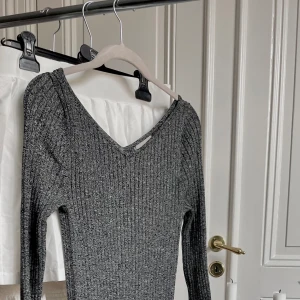 Lång tight bodycon-klänning - Gråmelerad bodycon klännibg som kan kläs upp eller ned. Fin krage som framhäver nyckelbenen och elegant design. Nyskick och endast testad. 🩶