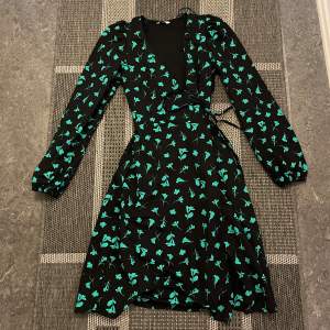 Fin oanvänd långärmad klänning med gröna mönster/detaljer. Aldrig använt 