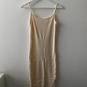 Två enkla beige och brun sommarklänningar - Vit/beige och brun sommarklänning, har slits nertill, ej anväds många gånger, stretchigt material