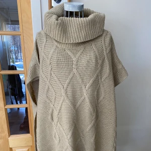 Poncho - Superfin stickad poncho, halv öppet på sidorna 