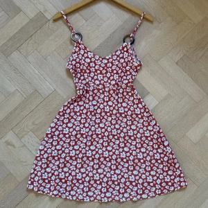 Sommarklänning - Söt och blommig sommarklänning! Superskön och i bra skick! Röd-orange med vita blommor. Storlek 36. Passar bra i längden för mig som är 170 cm lång 🥰
