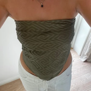 Sjal topp - En supersnygg militär, khaki grön sjal i siden/silke material. Mönstrad 81x81cm. Kan bäras på många olika sätt men jag brukar ha som en topp att knyta i ryggen som en bandeau topp. Perfekt för sommar och strand