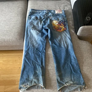 True religon  - Snygga trueys med unik ficka, tyvärr är dem av klippta vid fötterna och knapparna är utbytta till andra knappar, fråga gjärna om fler bilder om d är nått.   Ytterben: 95cm Innerbens: 70cm Midja: 94cm