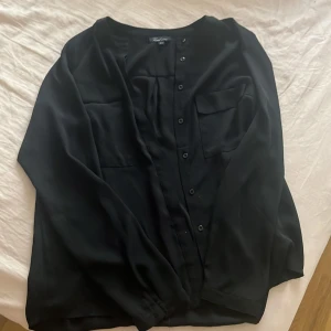 Svart skjorta  - Säljer en väldigt fin skjorta i färgen svart storlek Saldrig använd så är i väldigt bra skick men prislappen är tyvärr borttagen. Det är annars en väldigt fin skjorta som passar tills et mesta och kan användas vardagligt. Tyget känns som en blus.