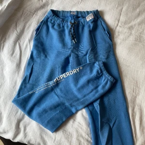 Sweatpants från Superdry  - Klarblåa mjukisbyxor från märket Superdry. Perfekt långa i benen för någon som är mellan 165-170🙌 Otroligt sköna och mjuka, inte supertjocka i tyget💙 Använda fåtal gånger men har inga defekter