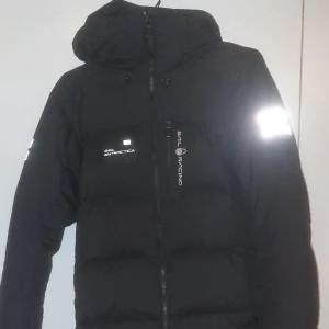 Sail Racing vinter jacka - Denna jacka var köpt förra vintern då jag använt den då och denna vinter, jag har tagit hand om den men ändå finns det små skador men som inte syns utifrån! Jackan är storlek S men passar mig som är storlek M.  Priset kan diskuteras!