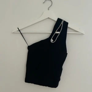 Svart festtopp  - Svart festtopp med strass detalj. Helt oanvänd storlek XS