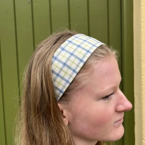 Rutigt hårband med knapp - Knappen, som sitter lite under örat underlättar påtagning genom att bland annat hindra att smink kladdar på hårbandet. Jättefin accessoar, perfekt till våren!