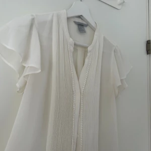 Vit topp - Vit vollang topp eller blus. Oanvänd och har inga defekter, jättefin och söt! Hör av dig om du har fler frågor!💕