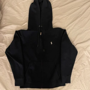 Ralph Lauren zip tröja - Säljer en Ralph Lauren tröja i färgen navy/mörkblå och storlek medium. Tröjan är i väldigt fint skick den köptes ny och inte använd mycket alls. Skriv vid frågor!