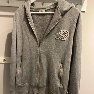 Moncler double logo zip  - Säljer min Moncler double logo zip. Bra skick.  Original pris 2900kr  Den jar gått sönder lite vid dragkedjan kolla bild 3, men funkar lika bra att dra upp den som innan. Pris kan diskuterats KÖP VIA POSTNORD 