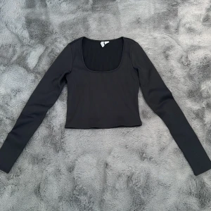Svart Långärmad  - Denna är i fint skick och oanvänd. Den är urringad med ribbat material. Superfin, stl S, H&M