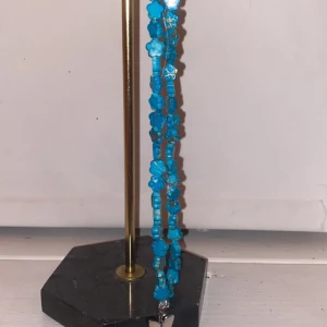 halsband - blått halsband med en fjäril som berlock. 