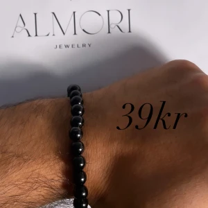 Svart pärlarmband från Almori - Ett elegant svart pärlarmband från Almori. Armbandet består av runda svarta pärlor och är elastiskt för att passa de flesta handleder.