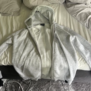 Grå hoodie med dragkedja  - Grå hoodie med dragkedja. Sitter lite smalare