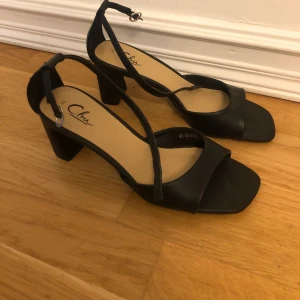 Sandal med klack  - Svart sandal med klack. Fint skick. Endast använd en kväll. 
