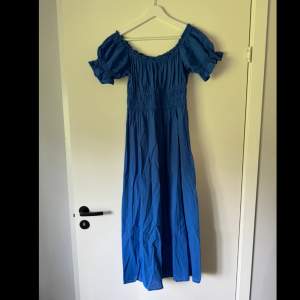En klarblå klänning med volangen som är midi/maxi lång. Går att ha både med fyrkantig urringning eller off shoulder. Nästan aldrig använd, jättefint skick. 