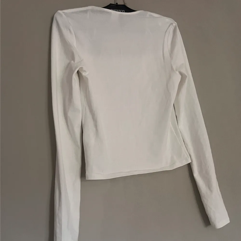 Säljer denna vita tröja med en rak urringning. Tröjor & Koftor.