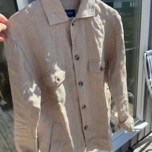 Eton linne overshirt  - Säljer nu min Eton overshirt då jag glömde skicka tillbaka den i tid, den är endast testad och har alltså inga defekter eller liknande. Den är i storlek XS men skulle defenetivt säga att den passar S också. Nypris 3900 kr. 