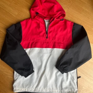 Vind jacka - Riktigt cool jacka med halv-zip som även går att vända in till en väska! Väl använd men i mycket fint skick bortsett från lite fläckar på det vita, dessa går säkert bort i tvätten om man ger det ett ärligt försök!