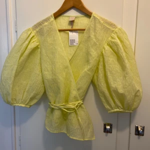 HM- Omlottblus - Axelbredd 43 cm, längd 56 cm. Omlottblus med ballongärm.  Aldrig använd och med prislapp kvar!