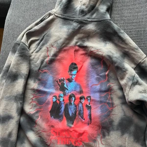 Stranger things hoodie  - Grå svart tröja me ett tryck på ryggen 