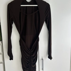 Klänning med bar rygg & rynkad resor från ASOS - Brun klänning med bar rygg och rynkad resor vid bakdelen från Asos. Storlek 36, passar xs/s. Kika bilderna för att se hur den sitter på! Buren endast en utekväll. 