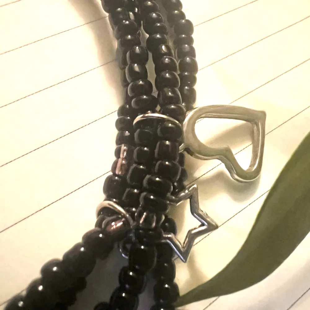 Armband i 4-rader med svarta och lila pärlor med silver detaljer . Accessoarer.