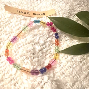 Armband  - Armband med transparenta glaspärlor på gulddetaljer på gummitråd 