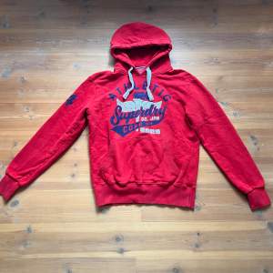 Vintage hoodie från Superdry i rött med märke både på framsidan och ärmen, skitsnygg! Säljer pga lite för stor. 
