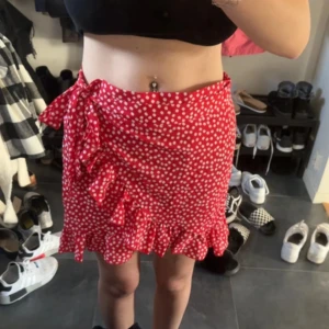 Kjol - En röd kjol, den går att knyta så jag skulle säga att den passar de flesta storlekar, den är relativt lång där bak och bra skick.