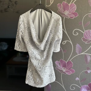 Glittrig Topp - Snygg topp som är öppen på bröstet. Glittrig ish grå topp men få paljetter. Den är från Kosovo och aldrig använt , vet ej storlek men S/M troligtvis