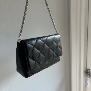 Handväska  - Svart handväska med silverfärgad kedja