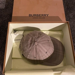 Burberry Keps - Burberry keps säljes nu i bra skick. Använd ungefär en sommar. Köpt från Farfetch för 3600kr med kvitto och allt annat kvar. Pris kan diskuteras vid snabb affär!  Storlek M