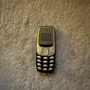 BM10 mini telefon - BM10 mini super mobil, ca 7cm.  Sim-kort samt micro-sd kort går att sätta i. Använd fåtal gånger, fullt fungerande.