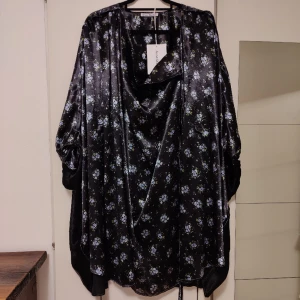 Acne floral kaftan - Snygg svart och blå kaftan-style klänning från Acne Studios i nyskick. Aldrig använd, bara provad. Köpt i april i år för 2 600kr på halva priset. Säljer på grund av felköp, originalförpackningen finns kvar.