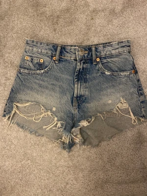 Zara jeansshorts - Snygga jeansshorts från zara som tyvärr är lite små för mig. Strl 34. De sitter som vanliga jeansshorts och är lite högre, men skulle inte säga highwaisted utan midrised. Jättebra skick, inga skador osv. Kostade runt 300kr, säljer för 100. Pris kan diskut