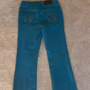 Säljer dessa lågmidjade turkosa jeans. innerbenslängden är 71cm och midjemåttet är 36cm