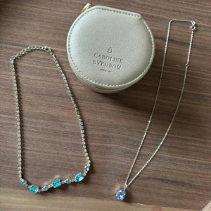 Caroline svedbom 2 halsband ord pris stora 1695 lilla 695 båda för 850kr -   Säljer två helt otroliga halsband från Caroline svedbom i färg silver / blå Dessa säljer jag då jag tyvärr inte är en silvertjeje utan föredrar guld. Halsbanden är sparsamt använda en gång/ styck  Perfekt som gåva till någon du tycker om.