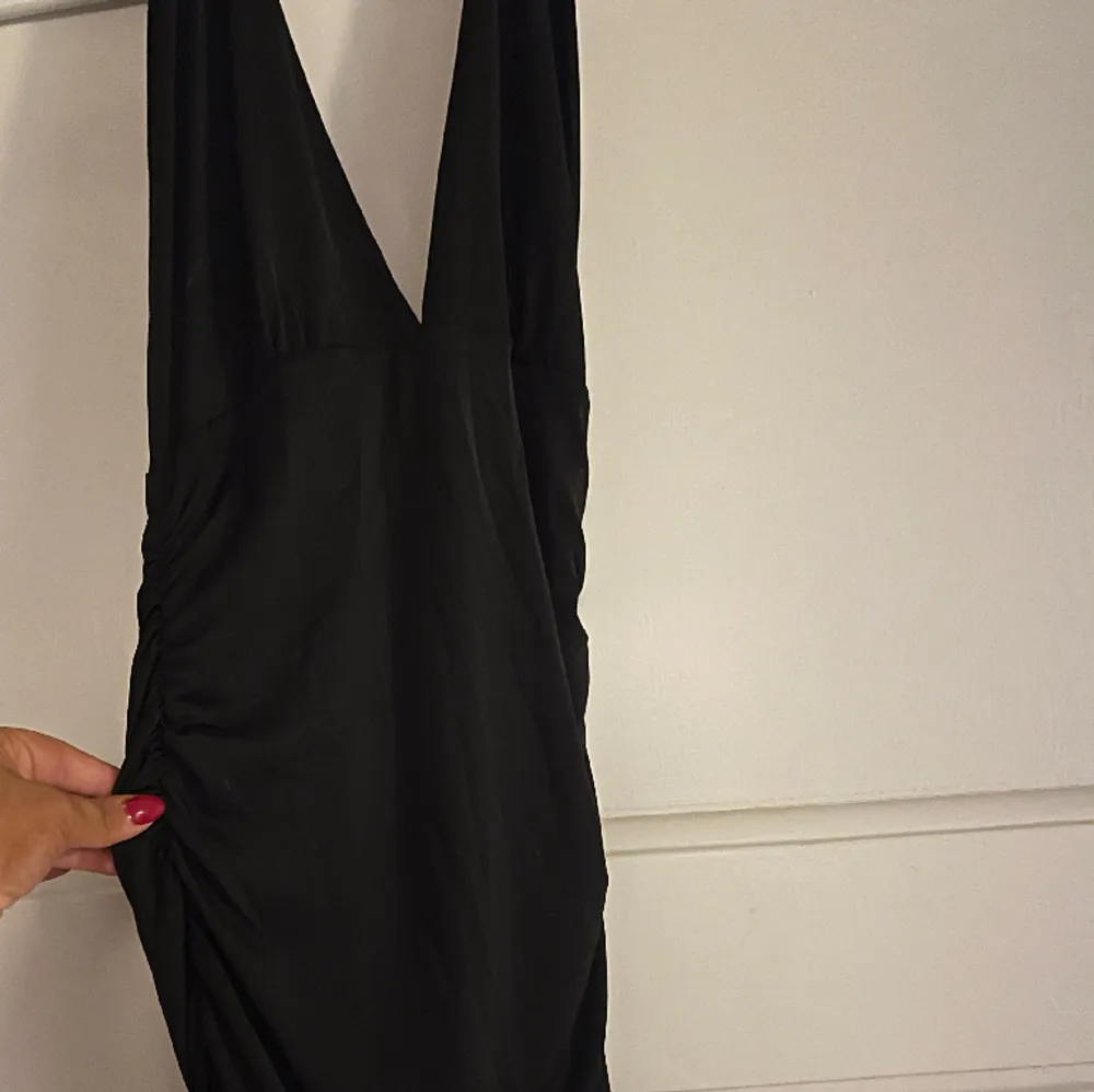 Supersnygg tajt svart klänning som är öppen i ryggen och halterneck. Är väldigt stretchig och har en djup urringning. . Klänningar.