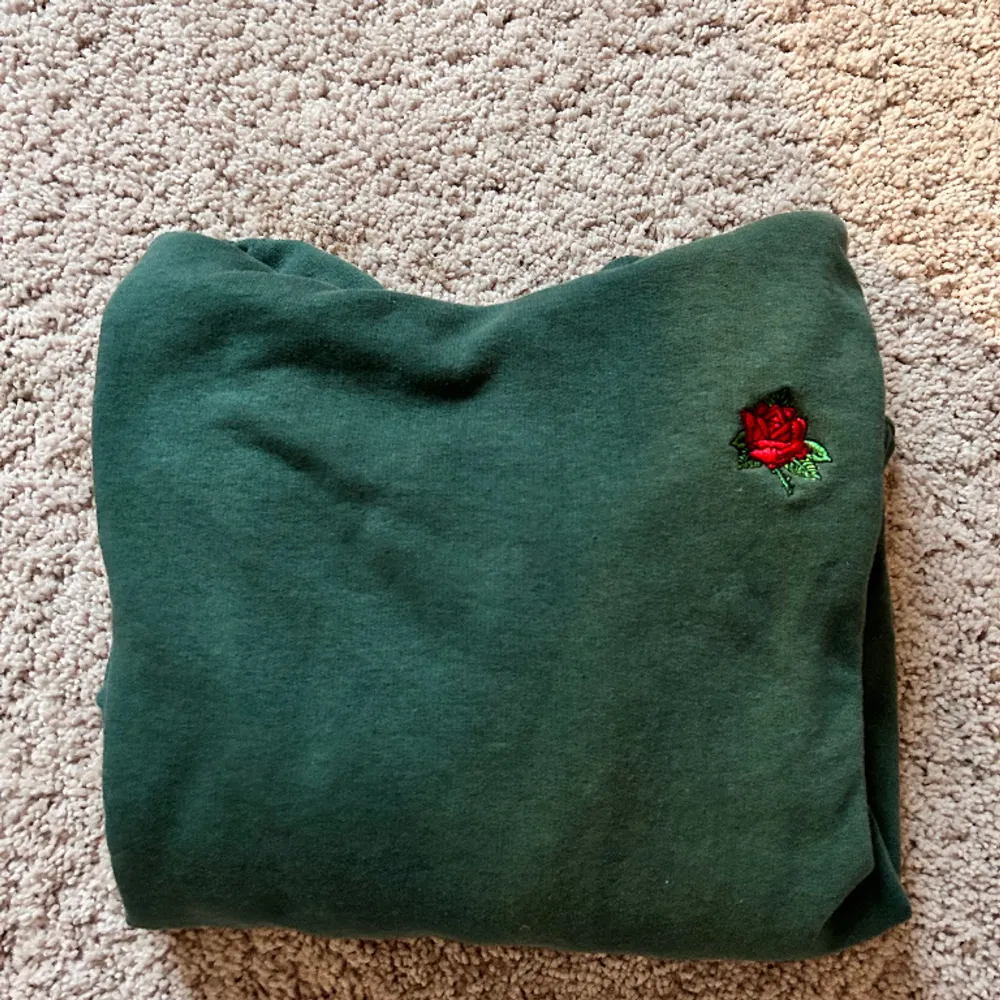 Skitstilig grön hoodie med en röd ros. Skitcool som alla älskar. Den är skitskön Används inte längre. Men älskade den. Hoodies.