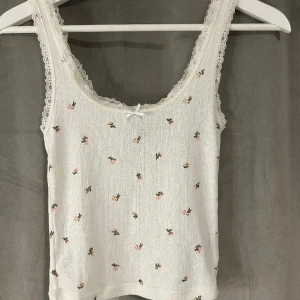 Spets linne - Ett vitt spetslinne med små blommor o en rosett på och lite ribbat mönster, använd fåtal gånger! ☺️Köpt på H&M!