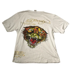 Vit y2k 2000s ed hardy t-shirt  - säljer denna ascoola ed hardy t-shirten! perfekt nu till sommaren! asnygg t-shirt. okej skick förutom defekter som inte syns så mycket på bild 3! om du har frågor så är det bara att kontakta mig.