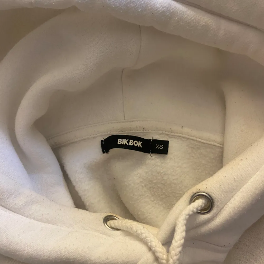 En superfin vit hoodie från Bikbok, säljer för att den inte används mer 💕superbra till sommaren och kan matcha den till en fin kjol, hör av er kring frågor :) Den är i XS men passar också mig som oftast bär S🫶🏼. Hoodies.