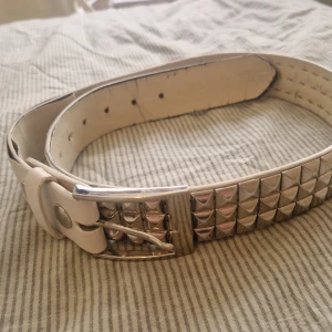 Nitbälte - Mycket använt nitbälte. Många defekter därav priset, men går att fixa med färg och limm. Bältet är 100 cm långt. Från remmens början till första hålet är det 70 cm, till sista hålet är det 85 cm. Kan skicka bilder på alla defekter!