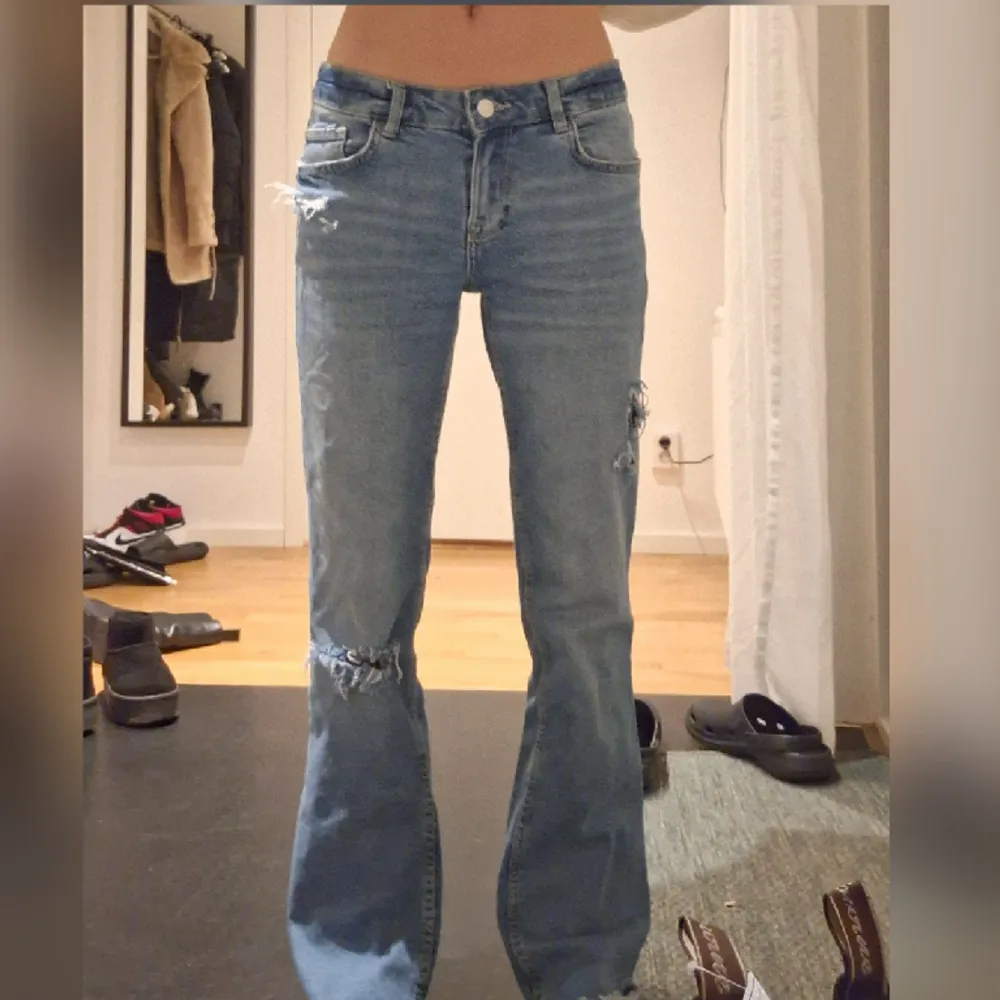 Låg midjade blåa jeans från bershka i storlek 34. Inga tydliga defekter vad jag kan se, detaljerna där bak har jag själv sytt på men går att ta bort om man vill. Skriv vid frågor💕. Jeans & Byxor.